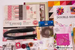 Detailausschnitt mit Embossing-Tool, Picture-Punch-Bastelstanze und Glitter in Lila und Grün.